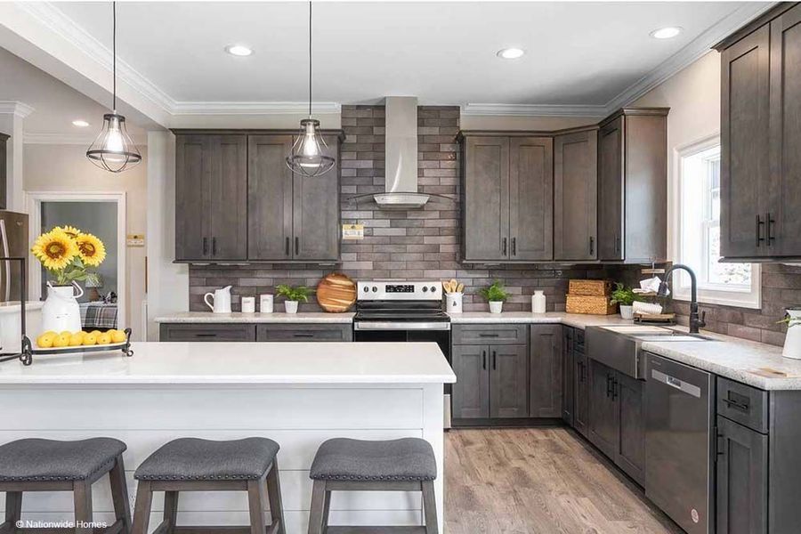 A modern kitchen featuring dark wood cabinets, a white island with three stools, and a brick backsplash.