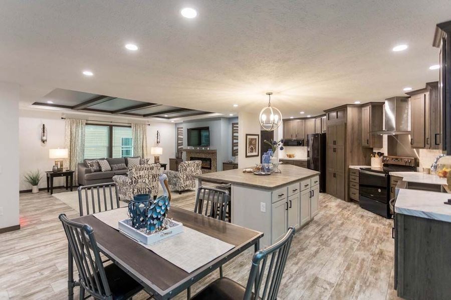 An open-concept living area with a kitchen, dining table, and cozy lounge space featuring wood-look flooring throughout.