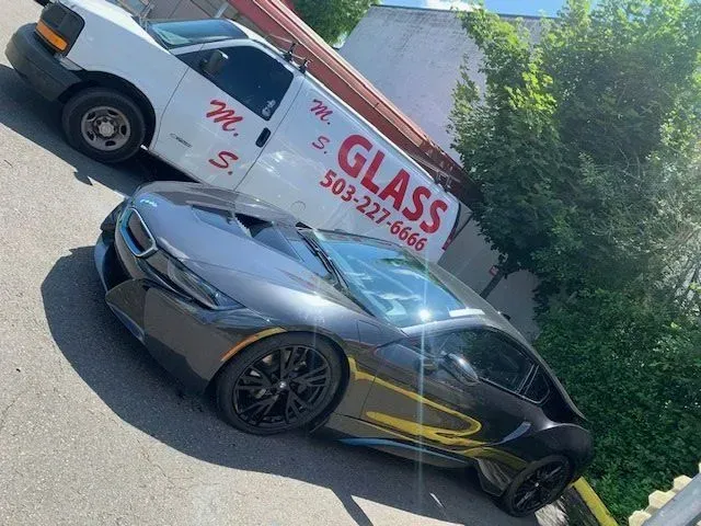 A dark gray BMW i8 parked next to a white 