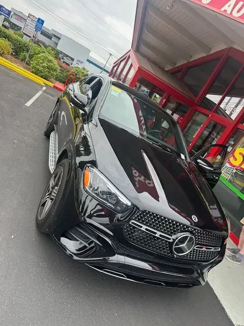 A black Mercedes-Benz SUV parked outside a car dealership.