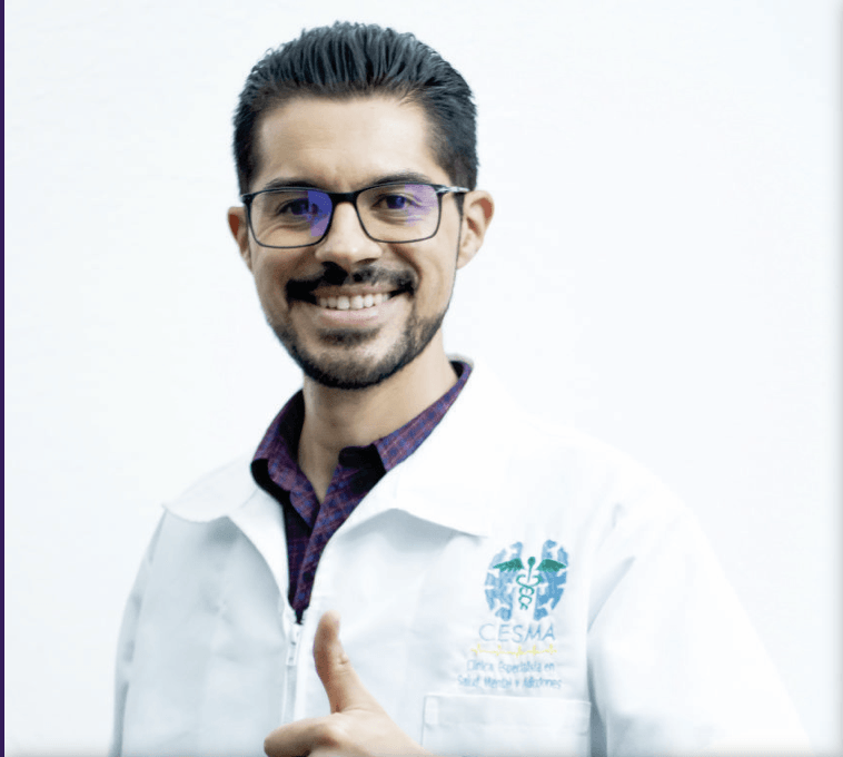 Un hombre que lleva gafas y una bata blanca está haciendo un gesto de pulgar hacia arriba.