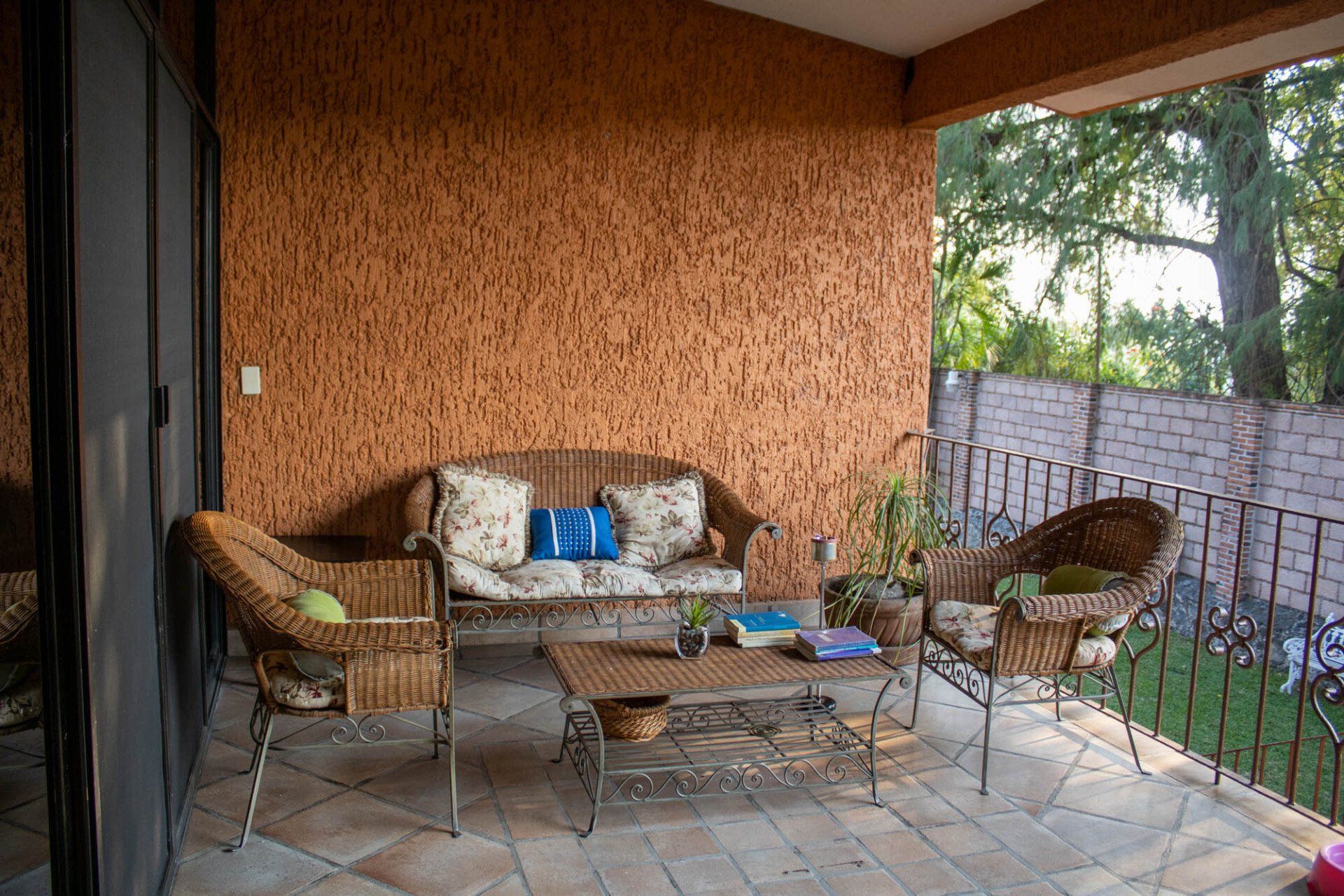 Un patio con un sofá, sillas y una mesa de café.
