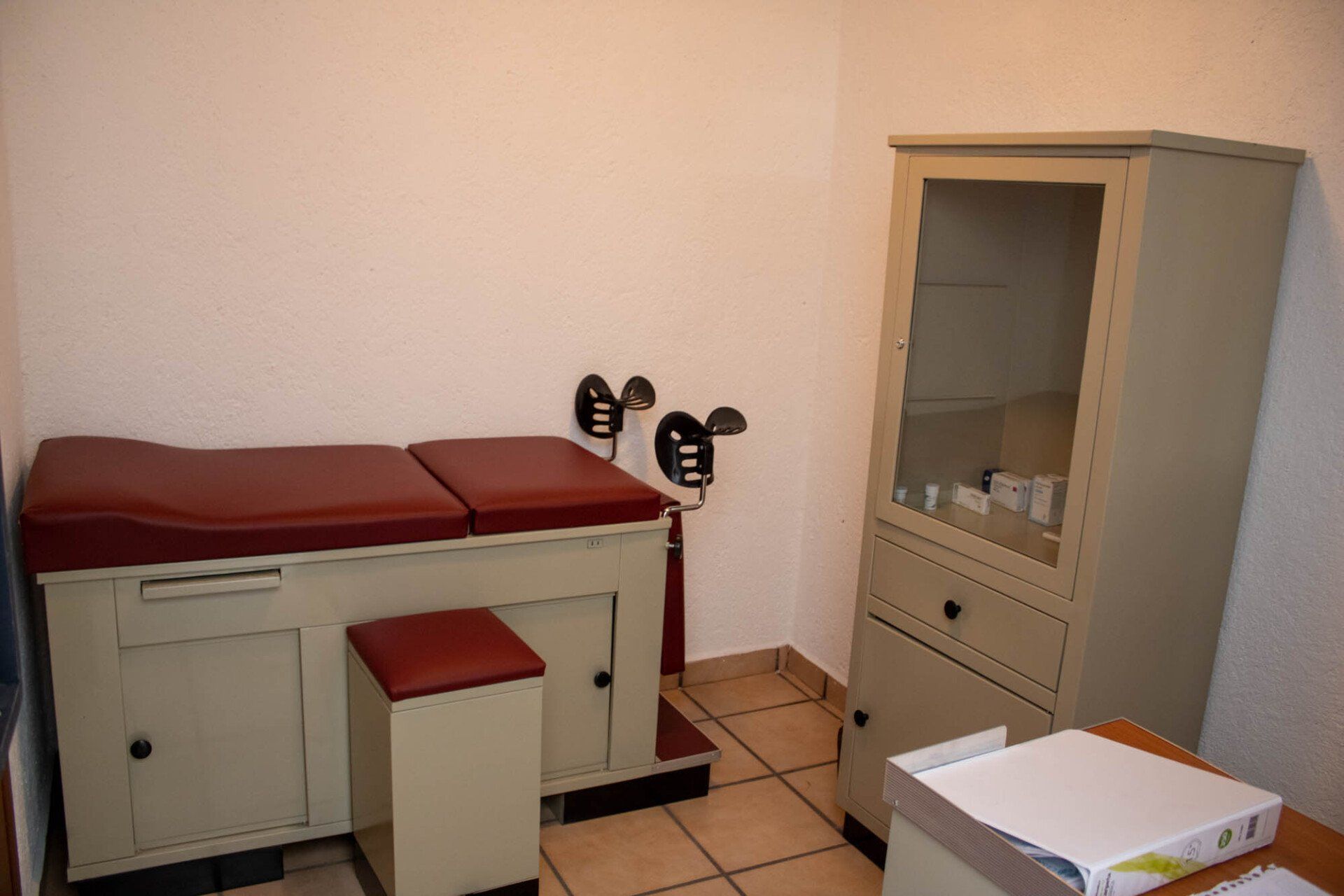 Un consultorio médico con un sofá y un gabinete.