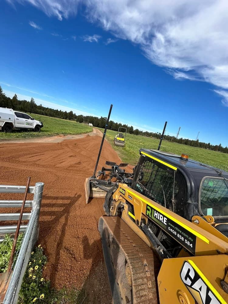 A Bulldozer is Driving Down a Dirt Road in a Field — RL Hire In Wellington, NSW