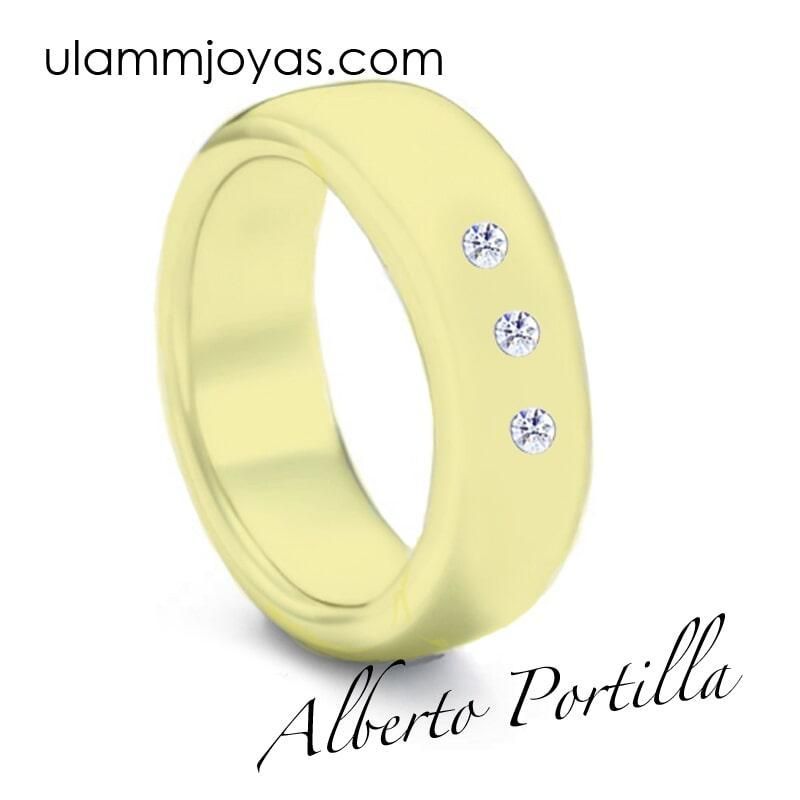 Un anillo amarillo con tres diamantes y la web ulammjoyas.com