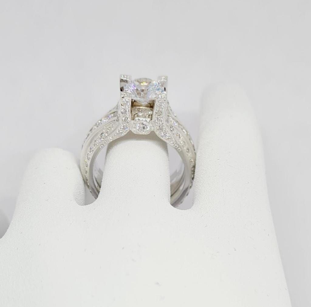 Un primer plano de un anillo de diamantes en el dedo de una persona.