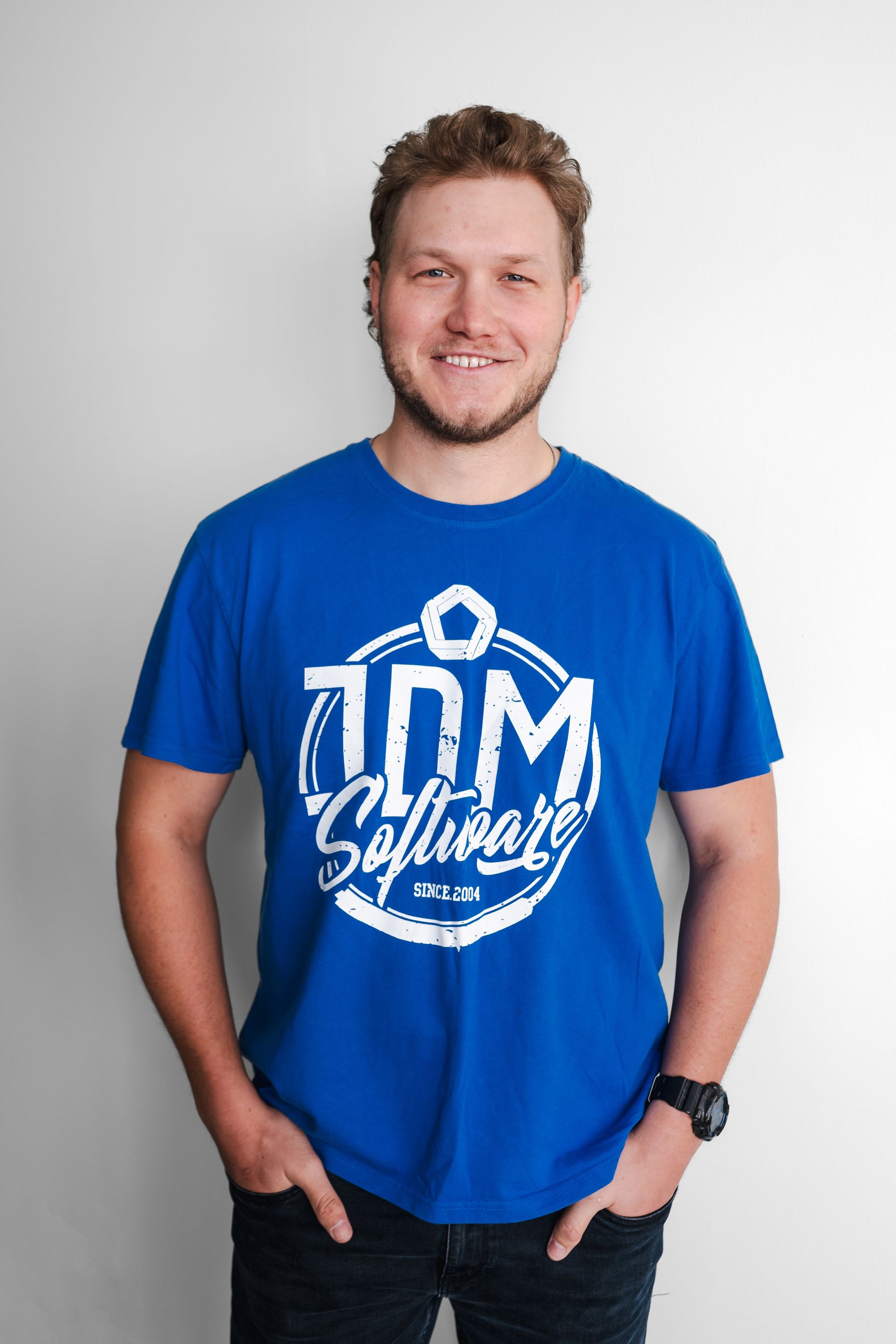 A man is wearing a blue t-shirt with the word software on it.