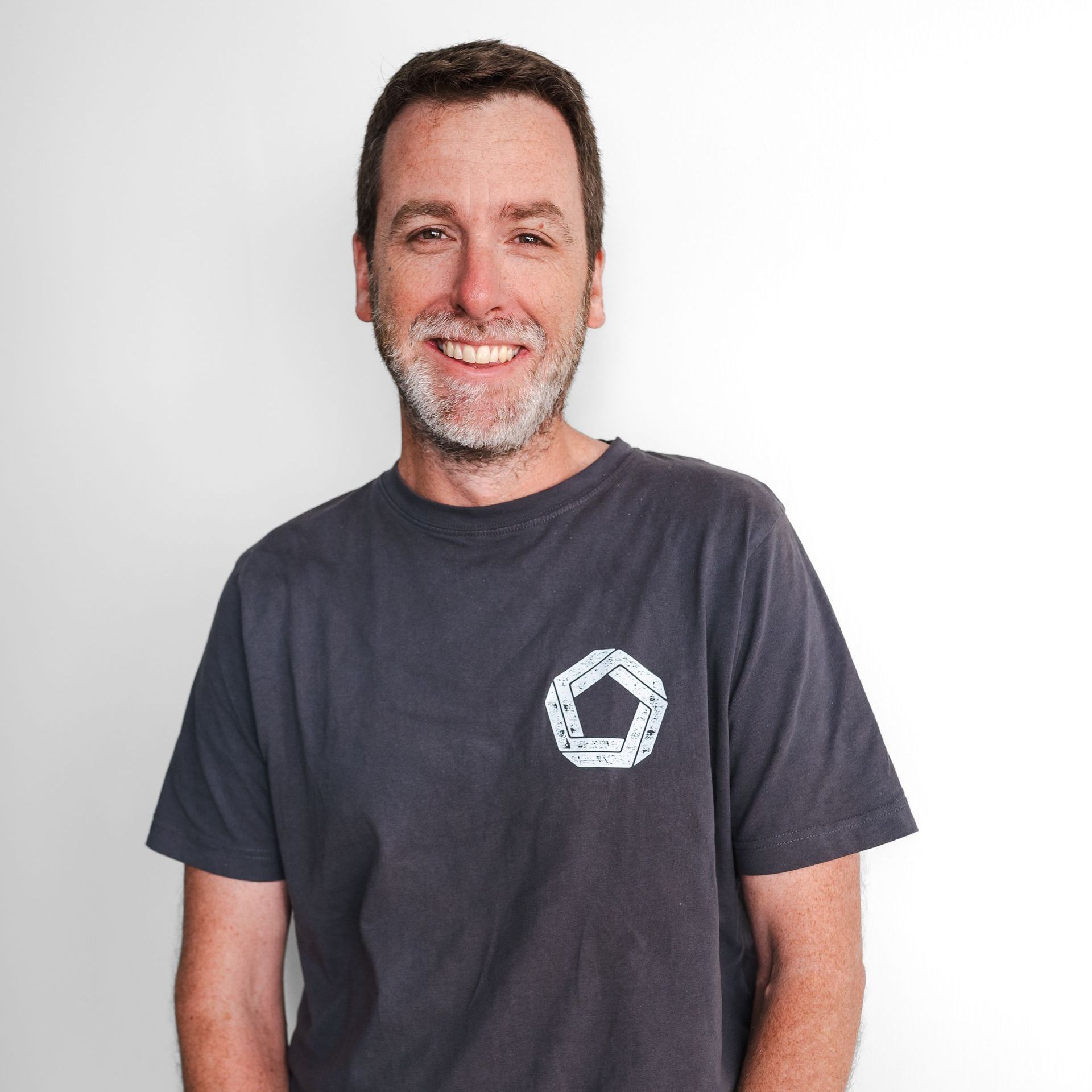 A man wearing a grey t-shirt with a white circle on it