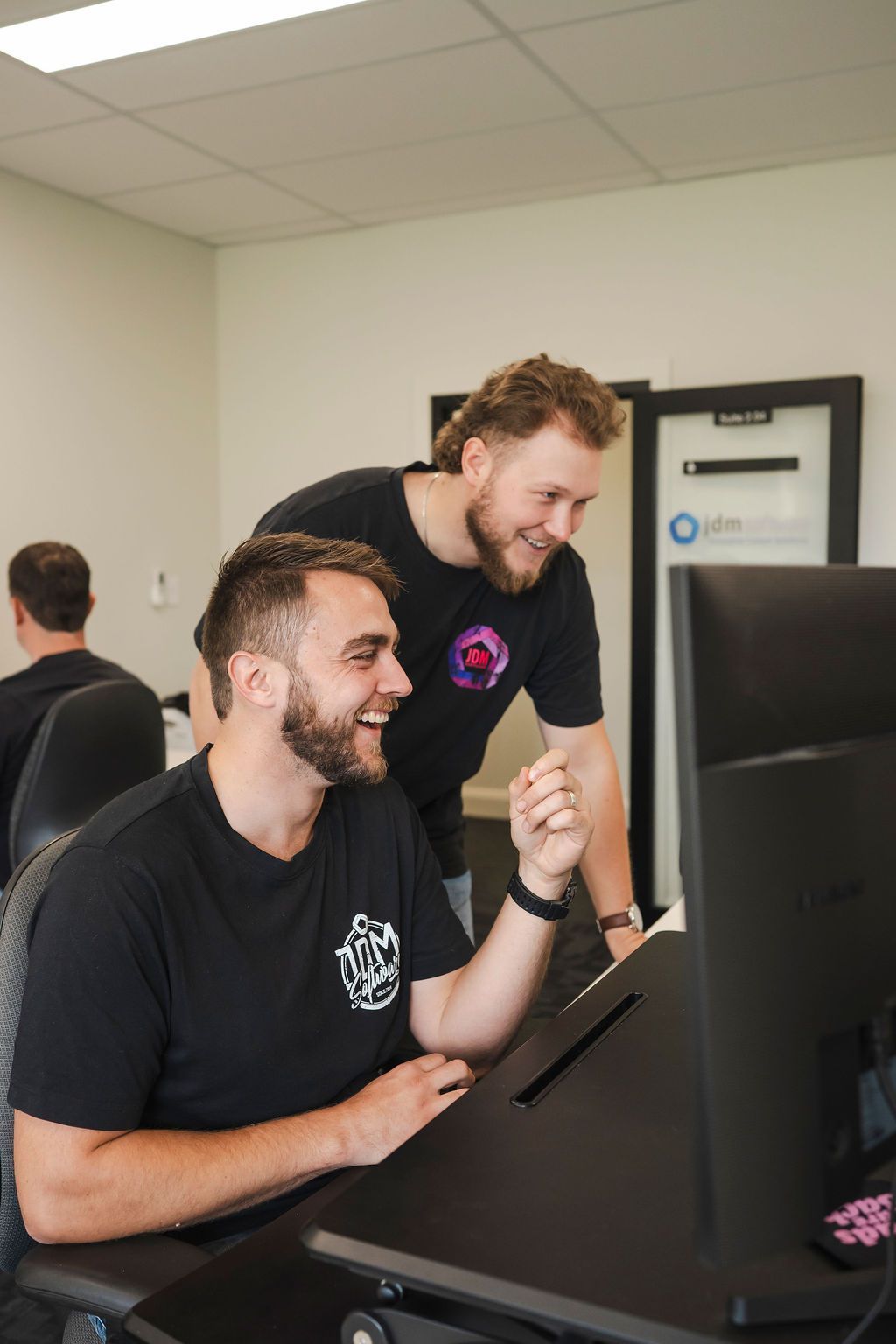 A group of men are looking at a computer screen