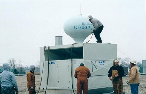 A man is standing on top of a george water tower