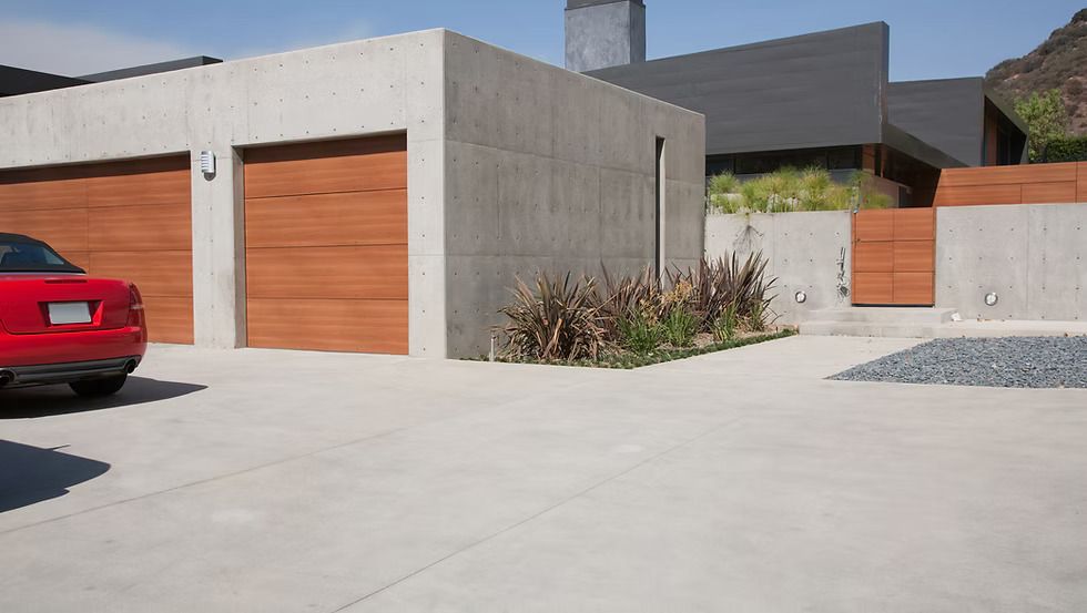 A red car is parked in front of a modern house.