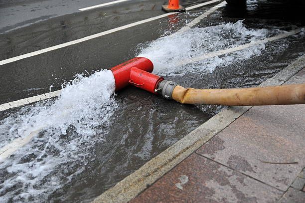  A fire hydrant pumps water into a flooded street during post-flood cleaning and restoration efforts