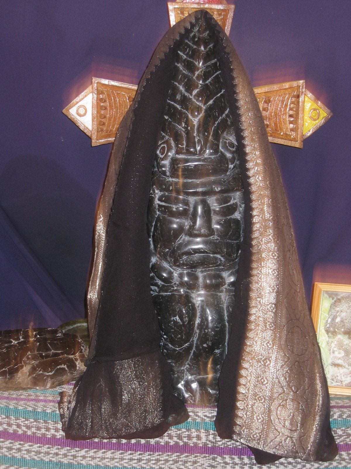 Eine Statue eines Mannes mit Kapuze und einem Kreuz im Hintergrund