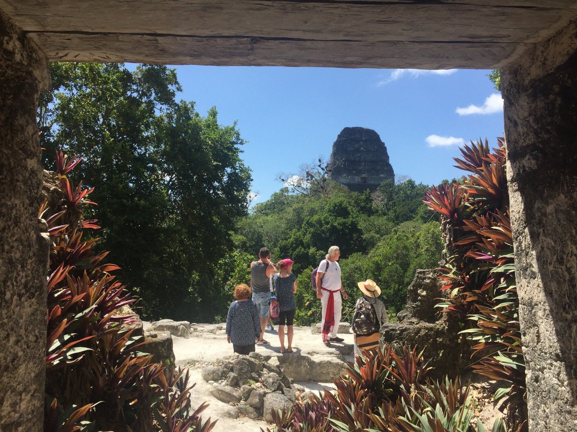 Eine Gruppe von Leuten steht auf einem Hügel und blickt auf einen Berg.