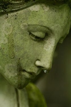 Eine Nahaufnahme der Statue einer Frau, der eine Träne aus der Nase läuft.