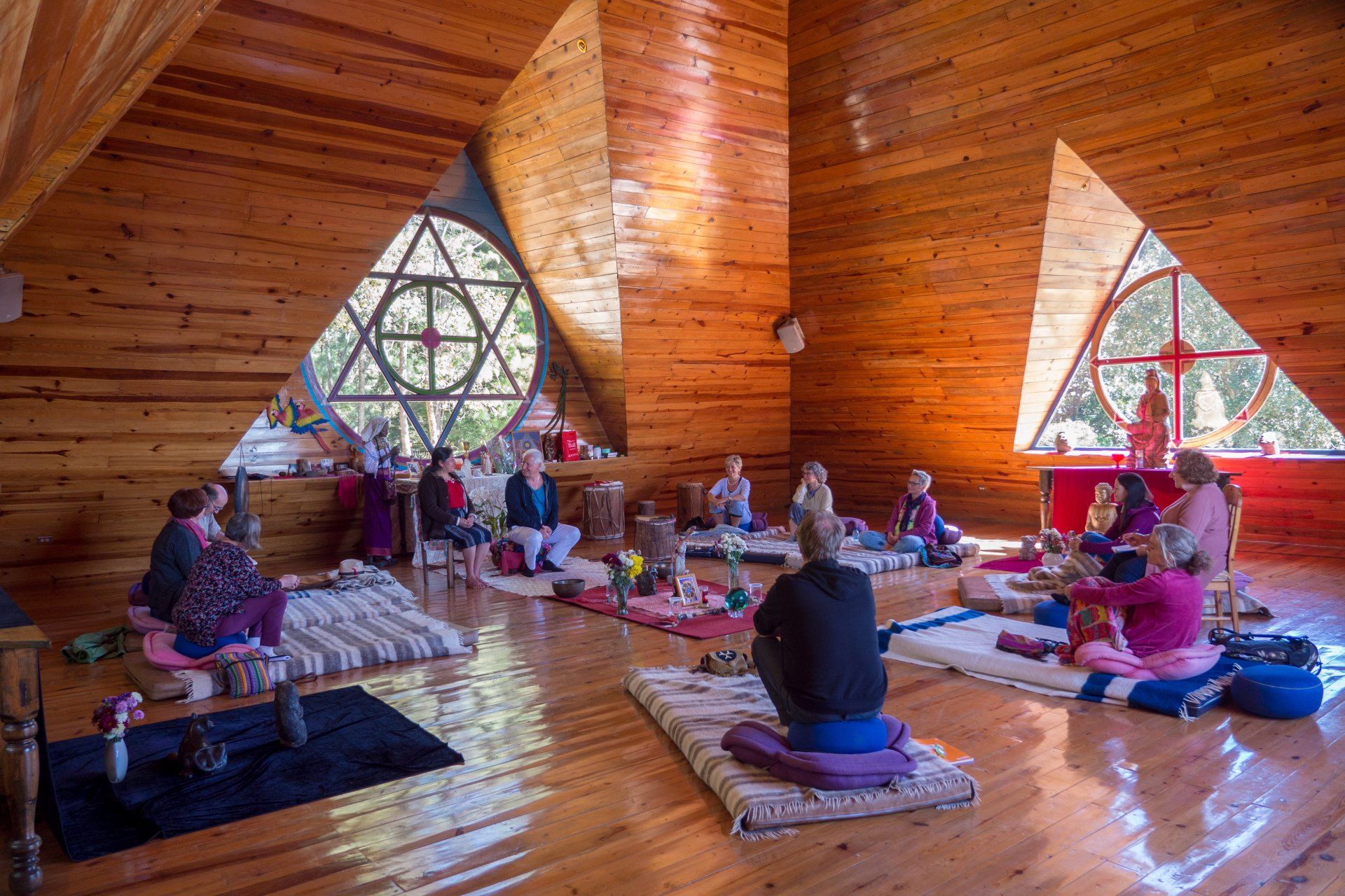 Eine Gruppe von Leuten sitzt in einem Holzraum auf dem Boden.