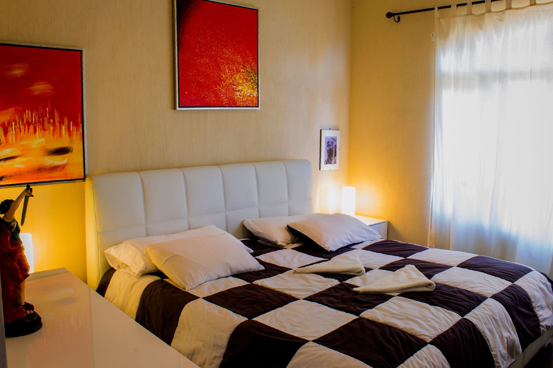 Ein Schlafzimmer mit einem Bett und zwei Gemälden an der Wand