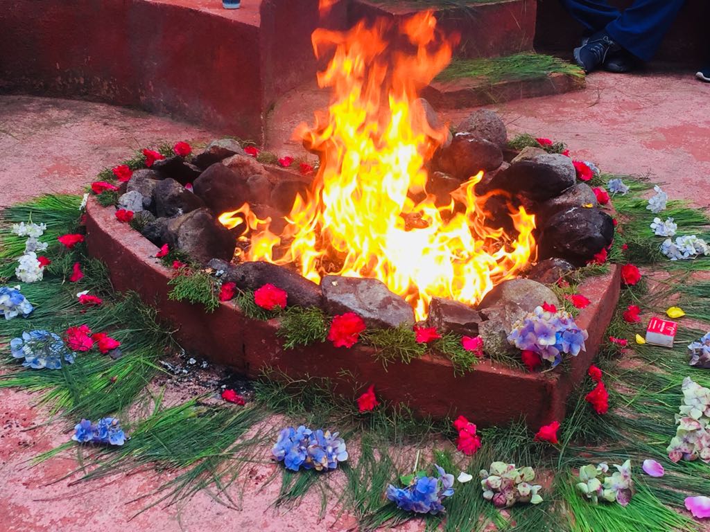 Ein Feuer ist von Blumen und Steinen auf dem Boden umgeben