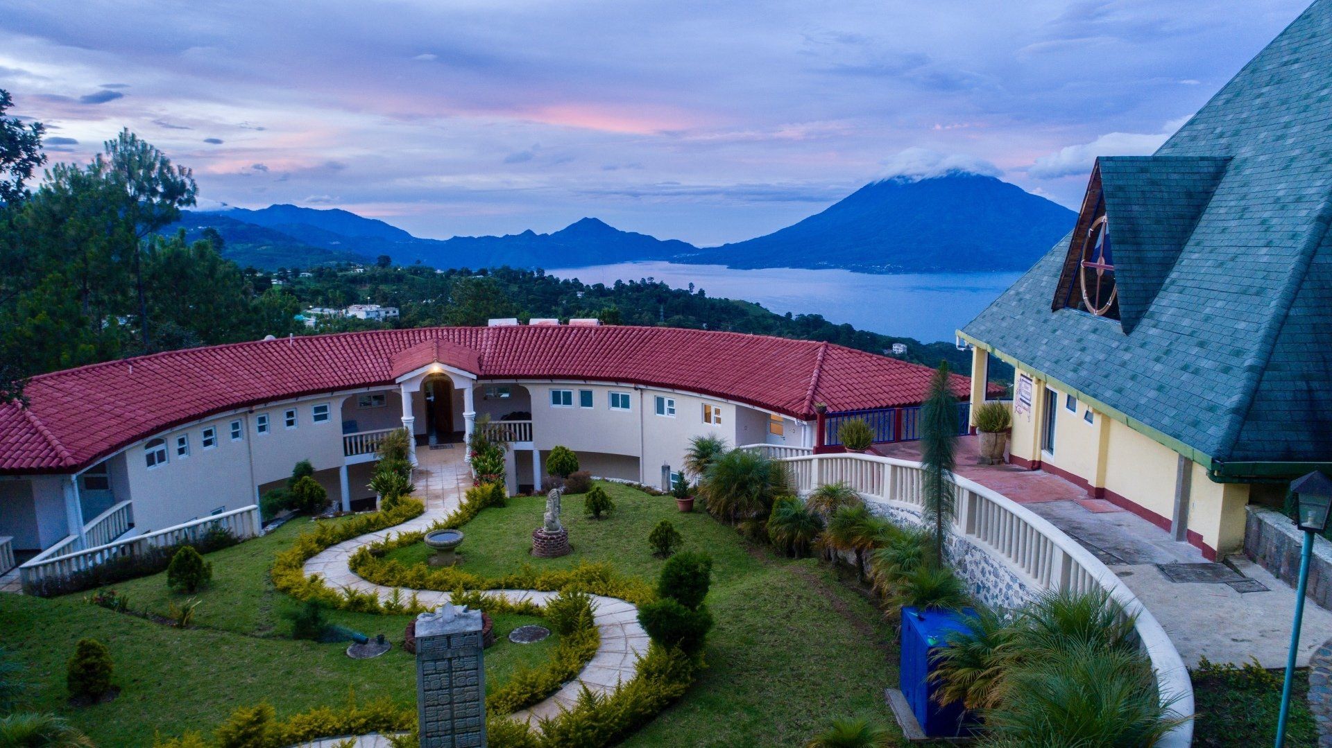 Eine Luftaufnahme eines großen Hauses mit einem See im Hintergrund.