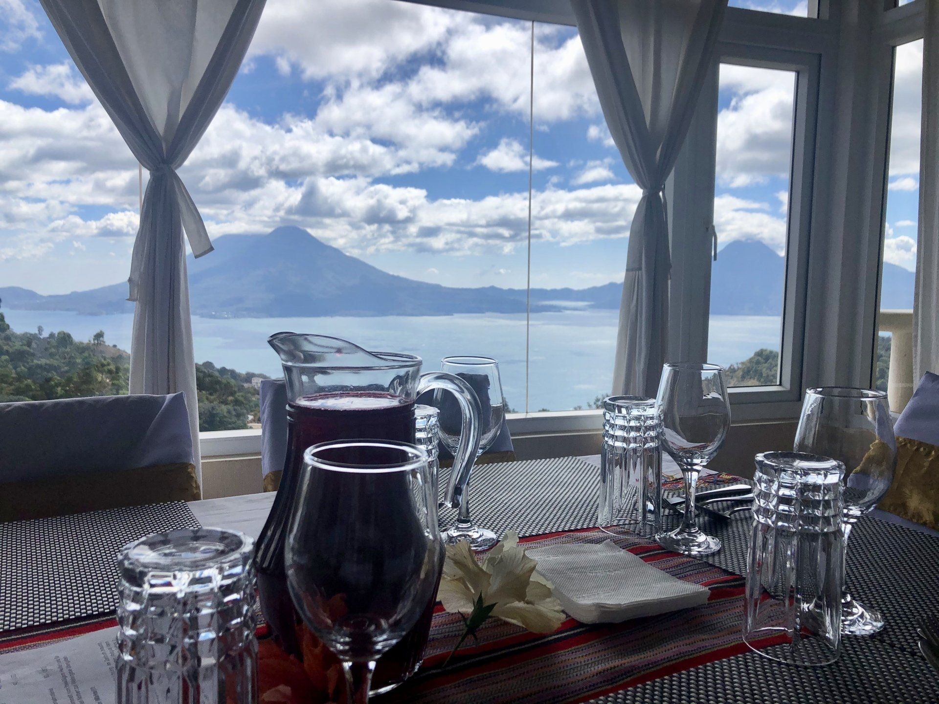 Ein gedeckter Tisch für eine Mahlzeit mit Blick auf das Meer und die Berge.