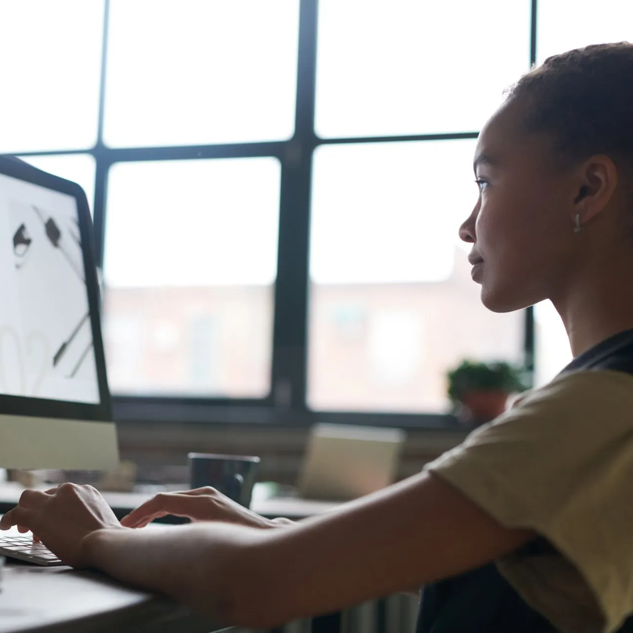 A side view of a young lady looking at a computer screen