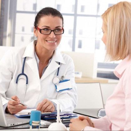 A female doctor is smiling while talking to a patient