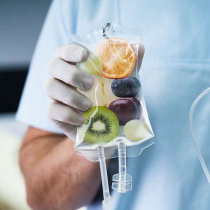 A person is holding a bag of fruit in their hand.