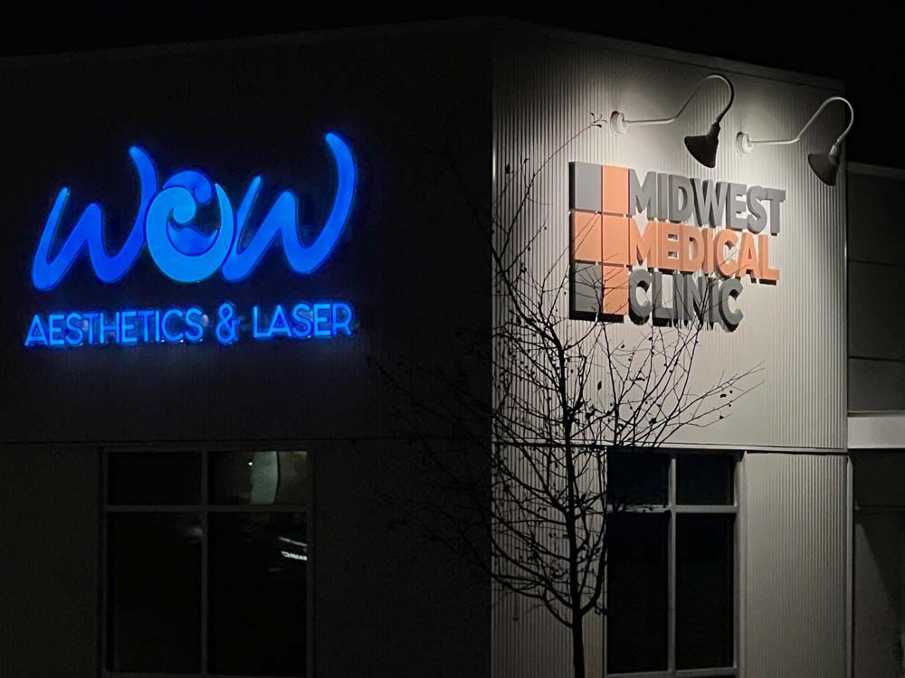 A sign for wow aesthetics and laser is lit up at night