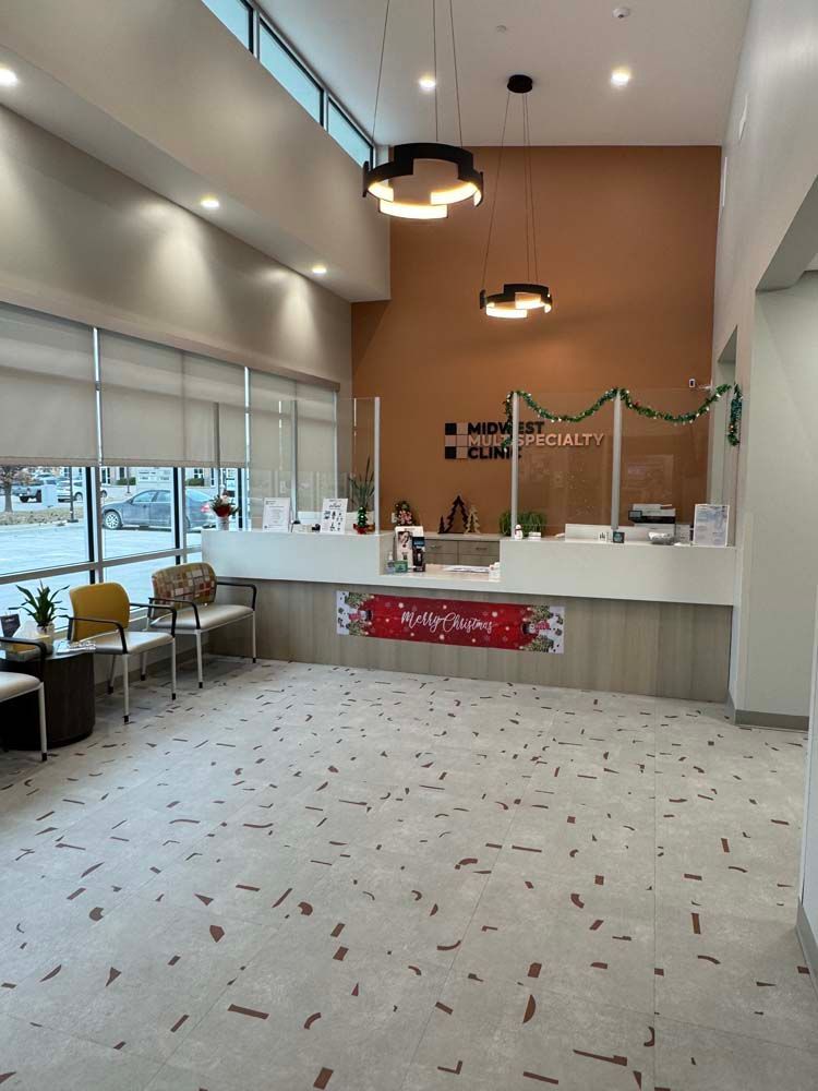 A large room with a reception desk and chairs in it.