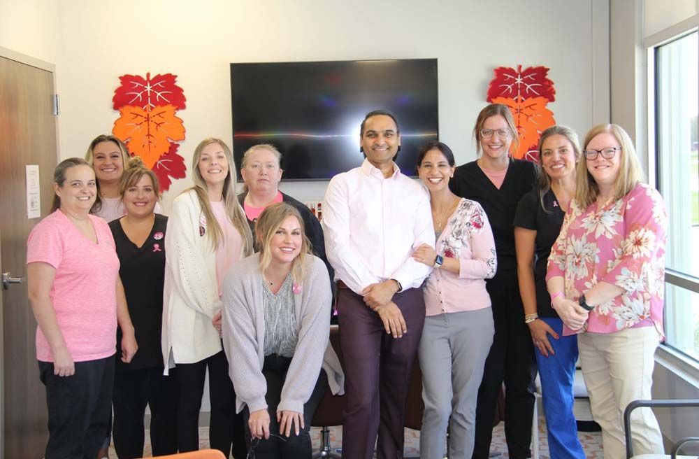 A group of people are posing for a picture in a room.