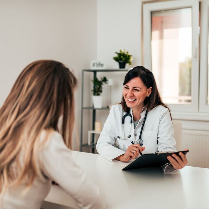 A female doctor is smiling while talking to a patient