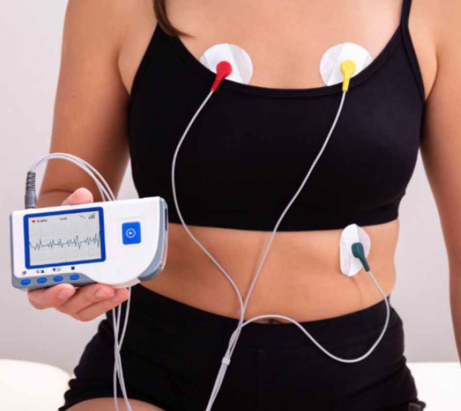 A woman is holding a device that shows a heartbeat