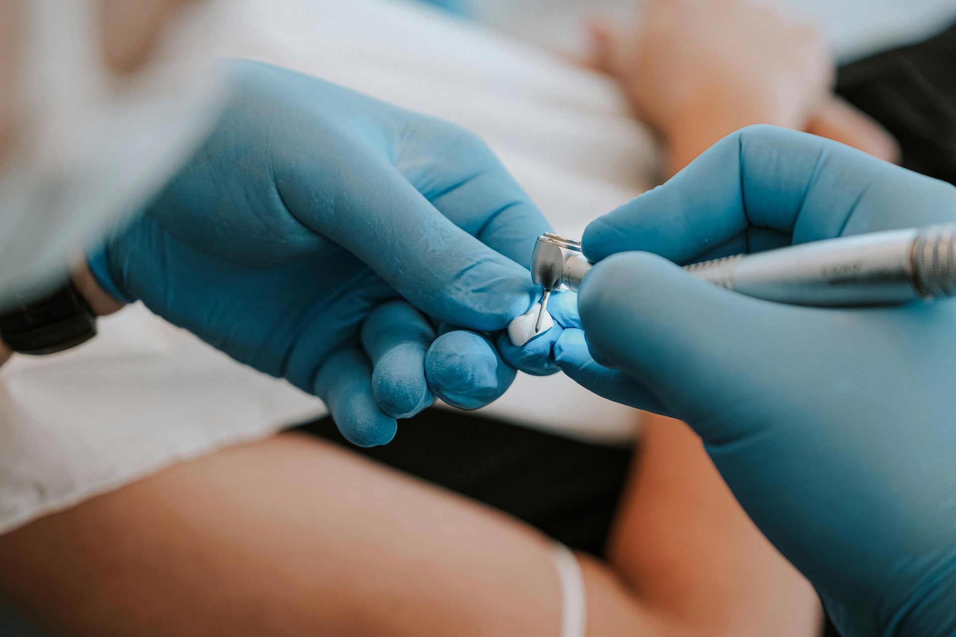 A dentist is working on a patient 's teeth with a drill.
