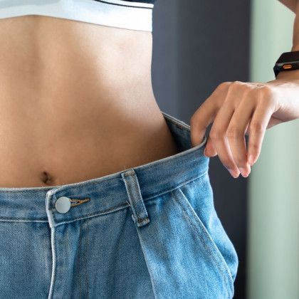 A woman is wearing a pair of jeans that are too small.