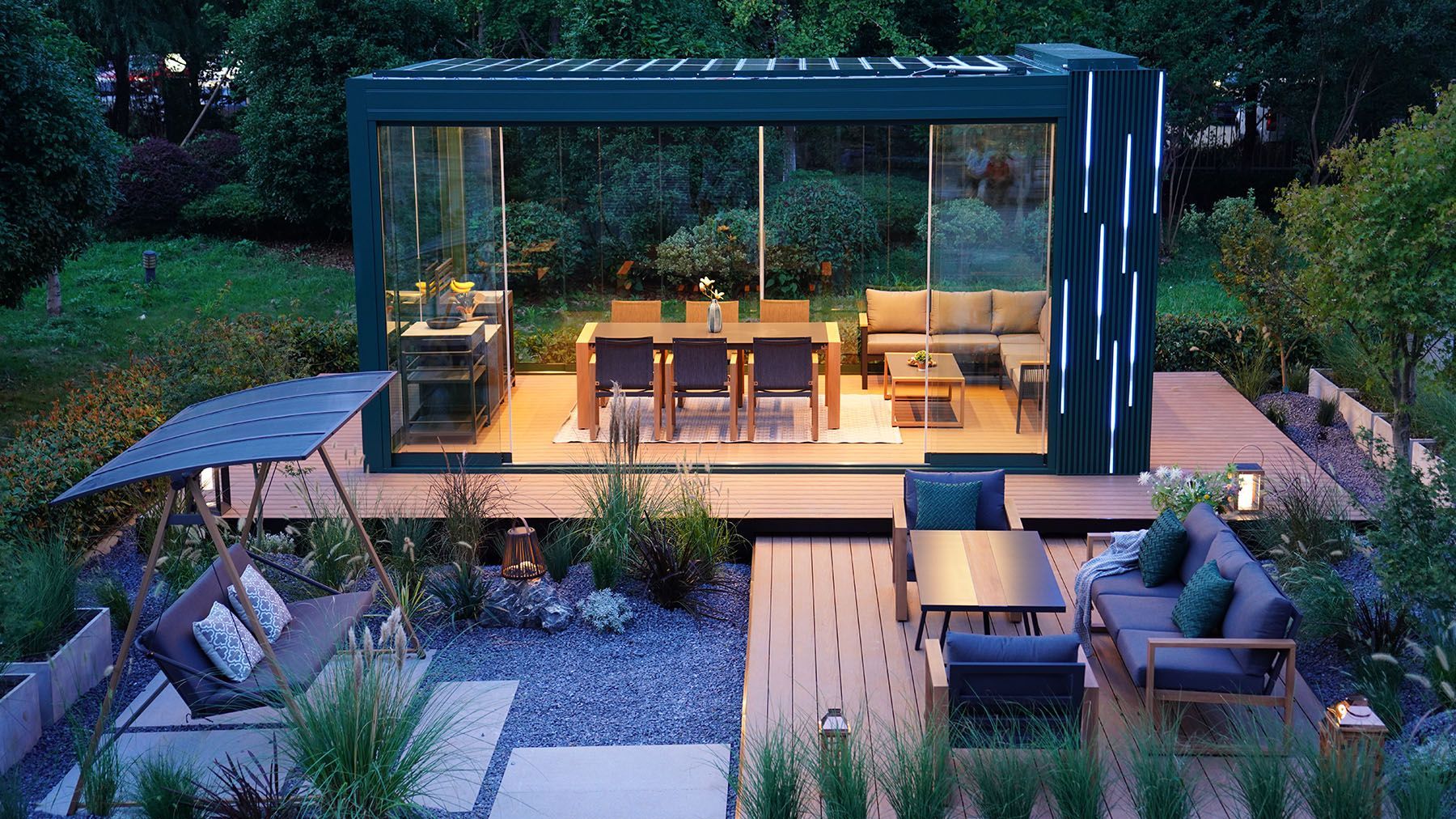 Modern outdoor living space with a dining area, seating, and a glass-walled structure.