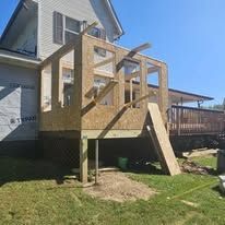 A wooden deck is being built on the side of a house.