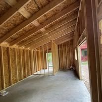 A room with wooden walls and a concrete floor is being built.