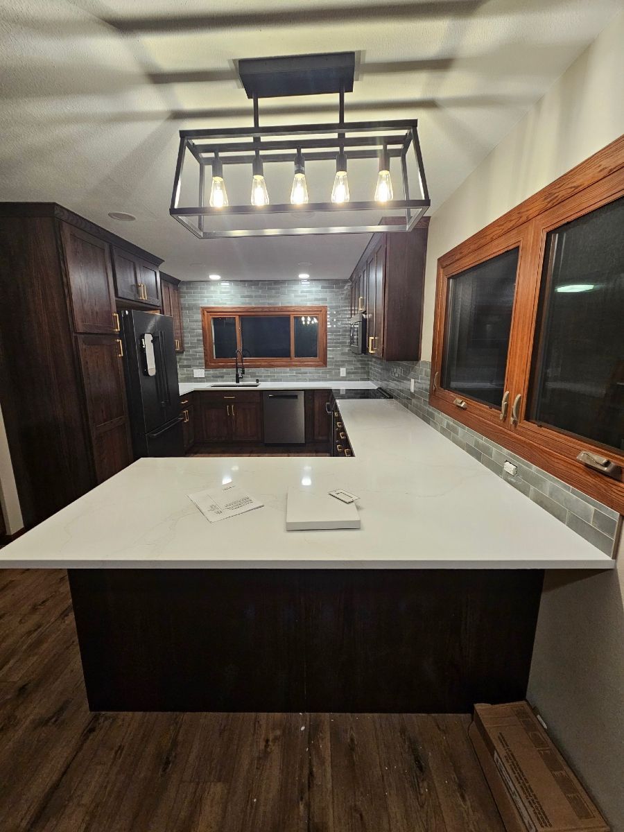 A kitchen with a large island and a chandelier hanging from the ceiling.