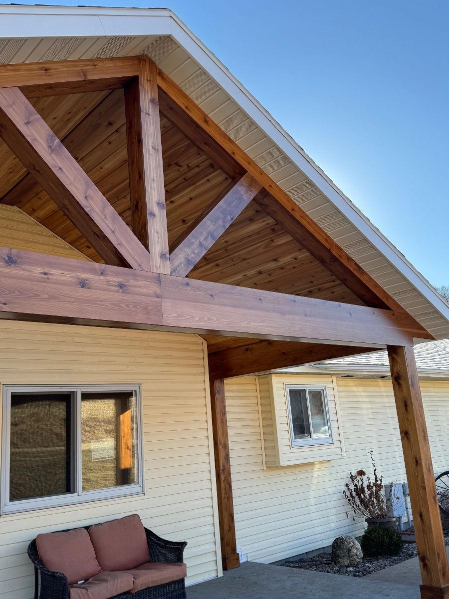 A house with a wooden porch and a couch in front of it.