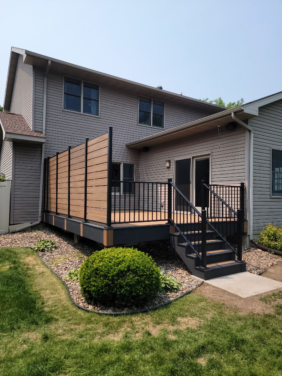 A house with a deck and stairs in the backyard.
