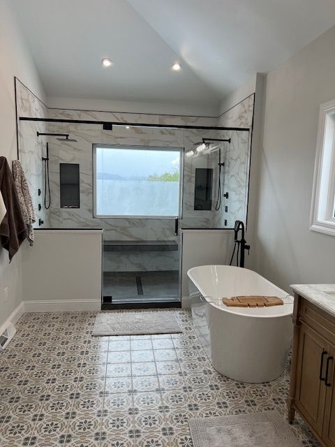 A bathroom with a tub , sink , and shower.