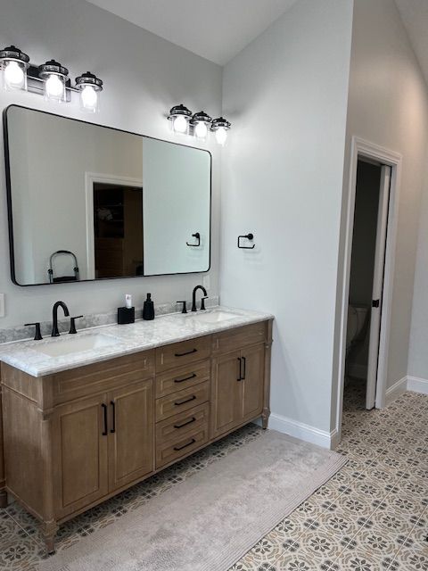 A bathroom with two sinks and a large mirror