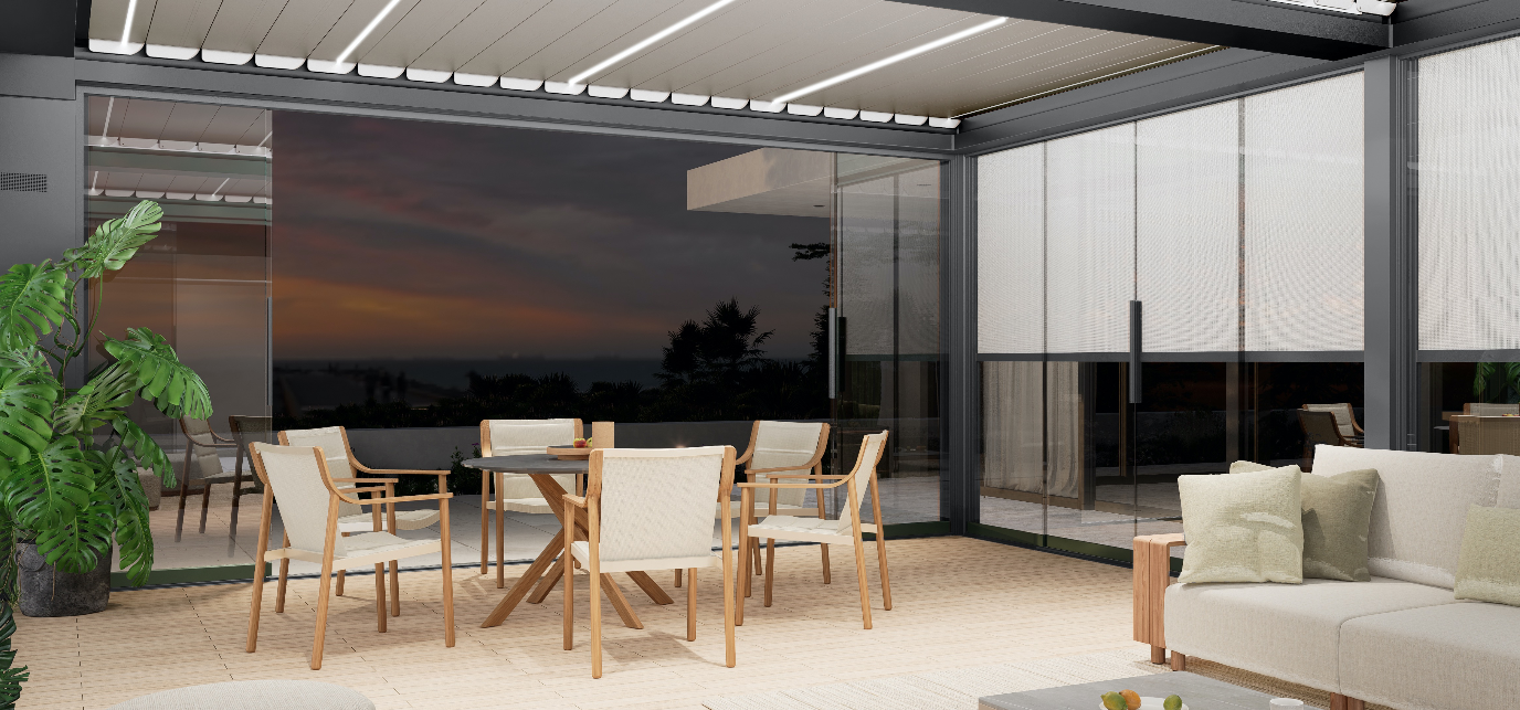 Outdoor patio with table, chairs, sofa, and retractable roof. Evening view with dark sky in background.
