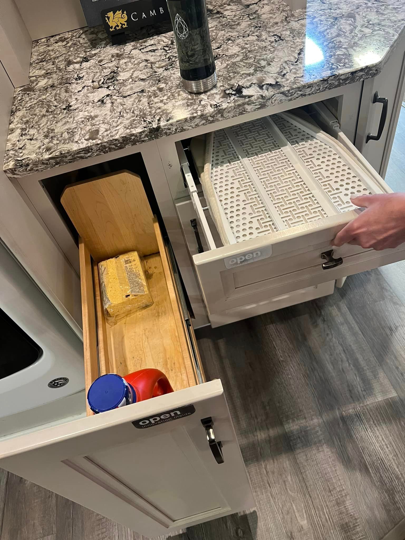 A person is opening a drawer in a kitchen.