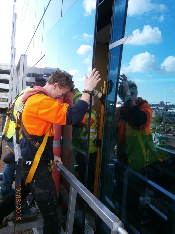 a man wearing an orange vest is working on a building