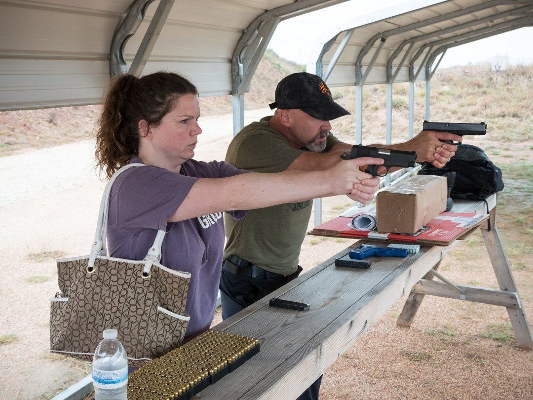 A Man Teaching a Woman How to Shoot