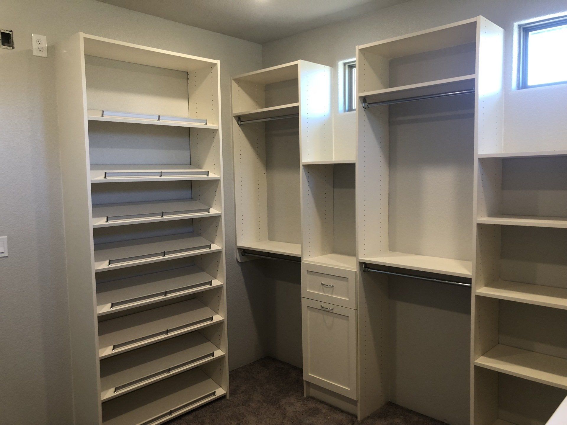 A walk in closet with lots of shelves and drawers.