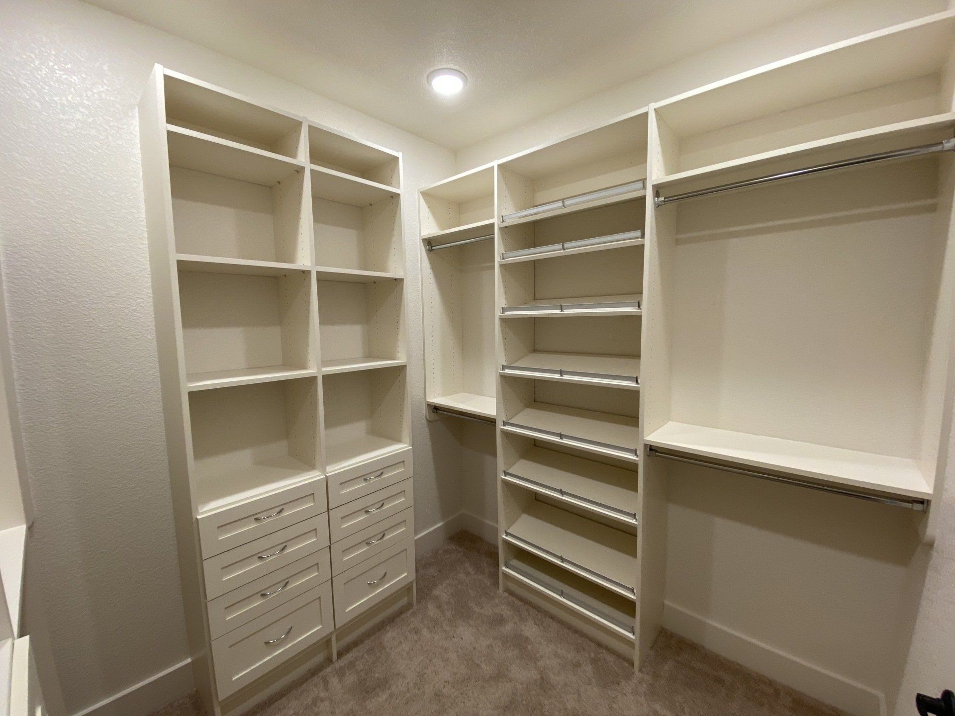 A walk in closet with lots of shelves and drawers.