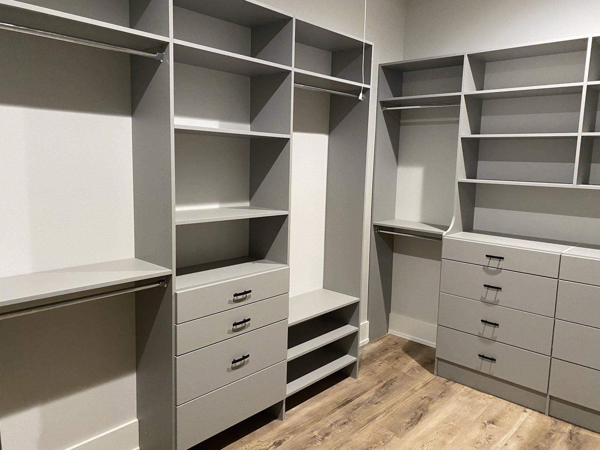 A walk in closet with lots of shelves and drawers