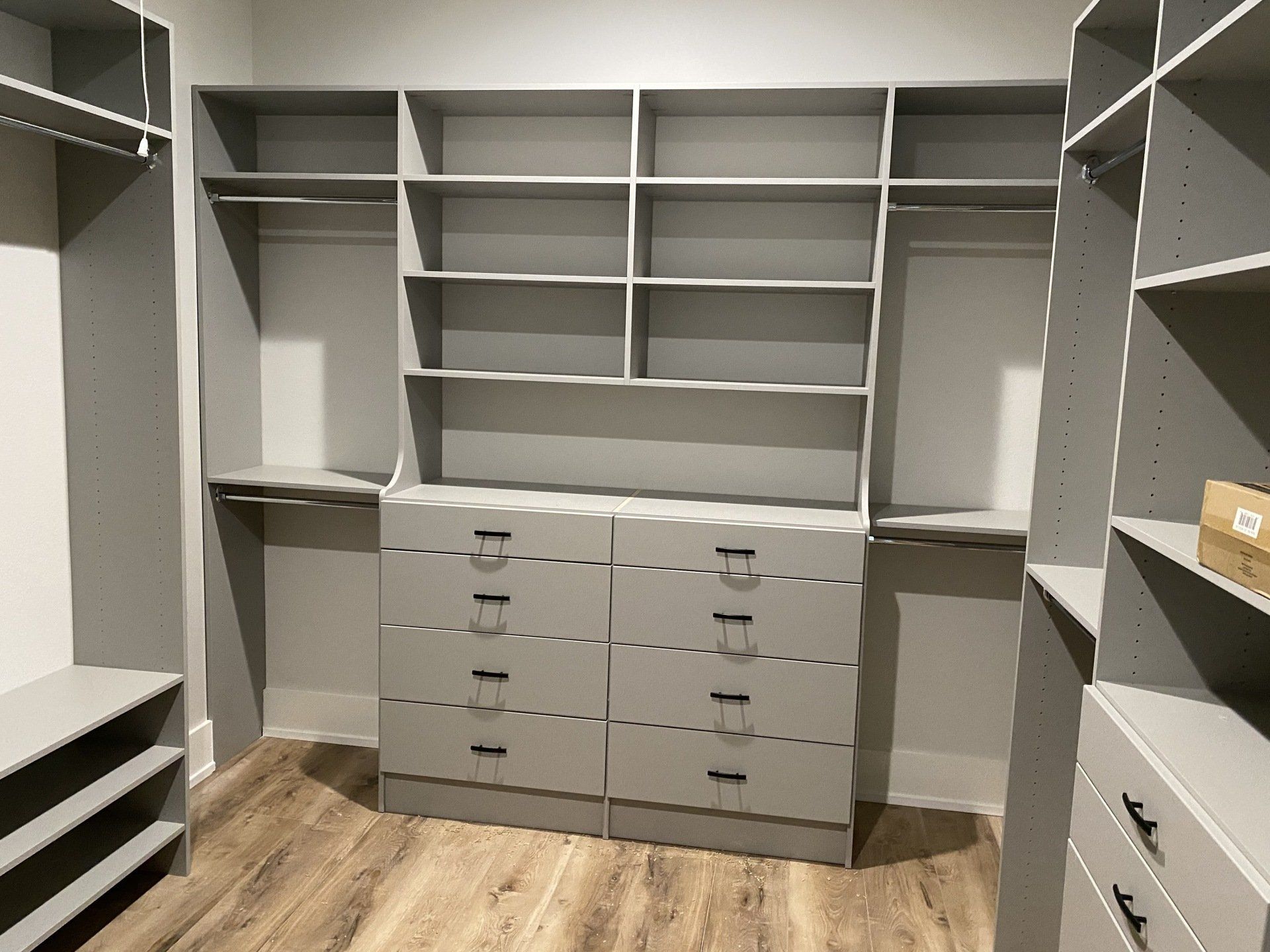 A walk in closet with lots of shelves and drawers